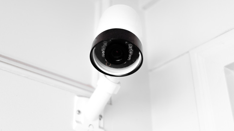 Close-up of outdoor security camera mounted above front entry to private residence