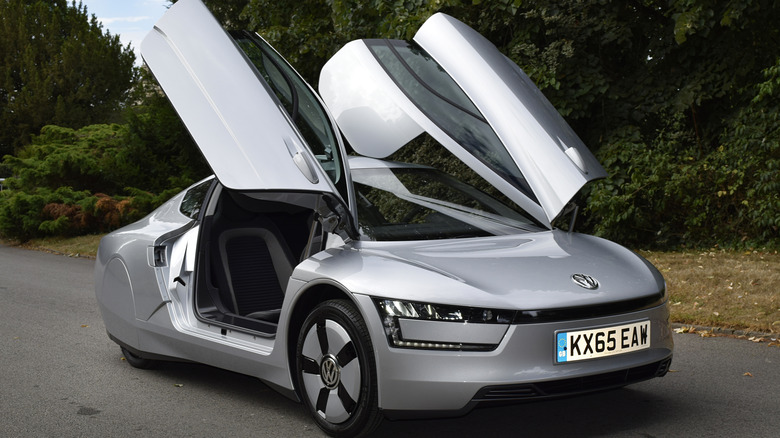 A Volkswagen XL1 parked with doors open