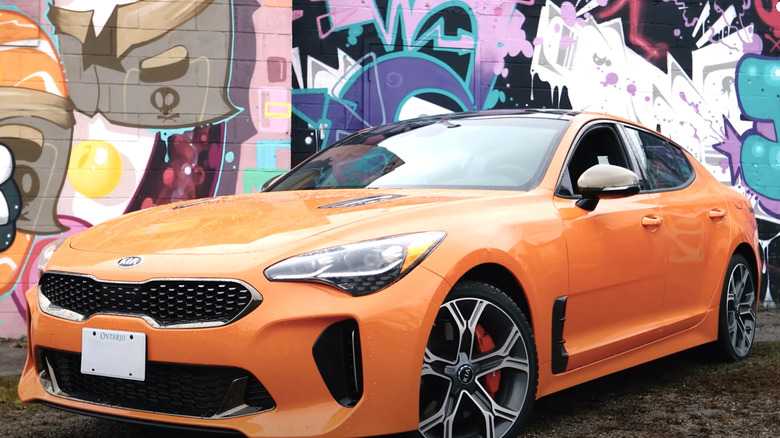 KIA Stinger GT2 parked in front of grafitti