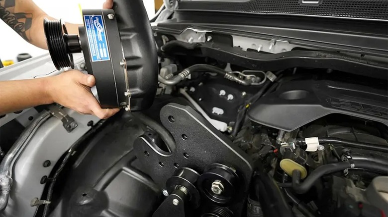 A technician installing a ProCharger supercharger on a RAM truck