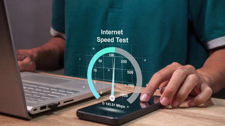 a person doing an Internet speed test on their smartphone and laptop with a graphic showing 143.51 Mbps