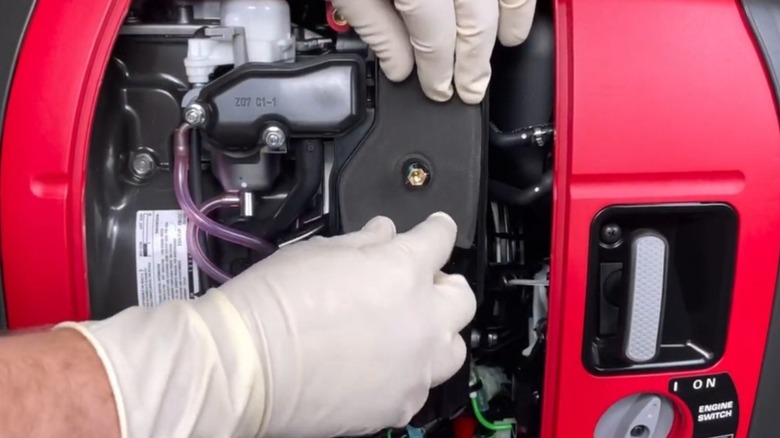 Servicing the air filter on a portable Honda generator after 100 hours of use.