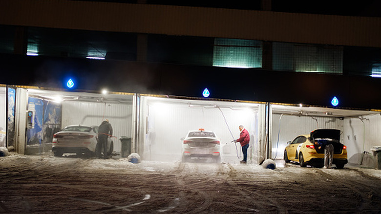 Taxi drivers in Russia washing their cars on a snowy evening