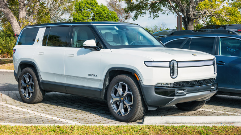 White Rivian R1S SUV at a parking lot, front 3/4 view
