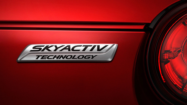 A Mazda Skyactiv technology badge on a red Mazda.