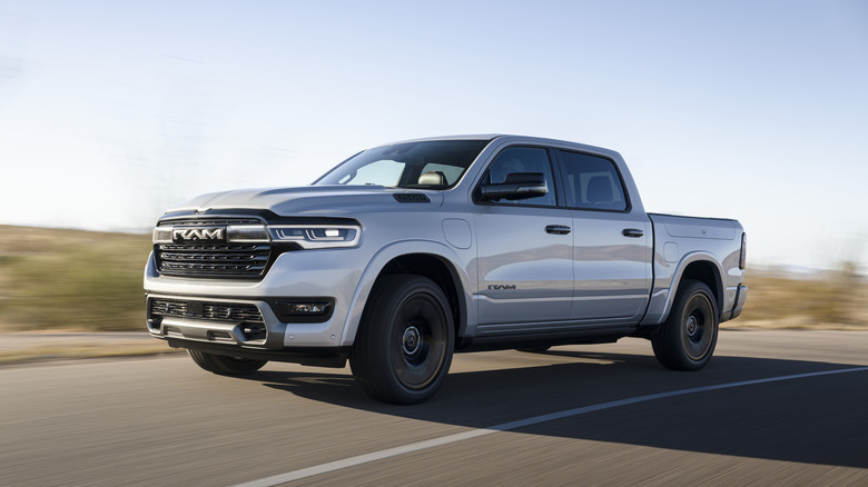 2026 RAM 1500 driving on country road, front-left 3/4 view