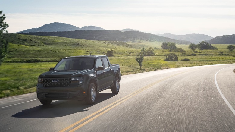 Black 2025 Ford Maverick driving along country road