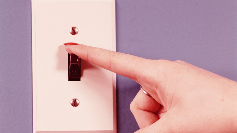 A person touching a light switch