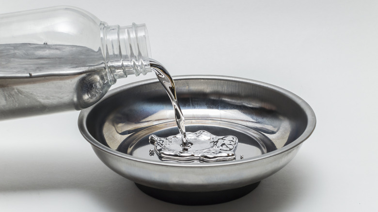 Pouring mercury into a steel bowl