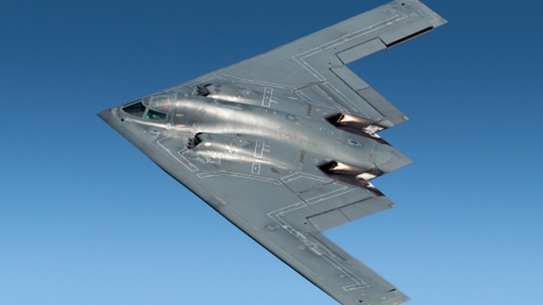 A B-2 Spirit banking left with blue sky in the background.