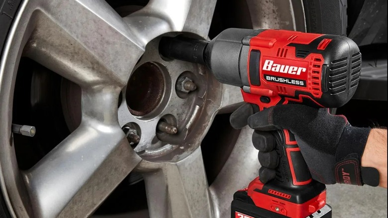 A Bauer drill being used on a car tire.