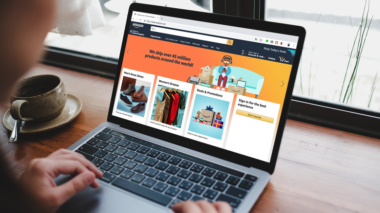 A woman using laptop showing Amazon logo and credit card shopping online