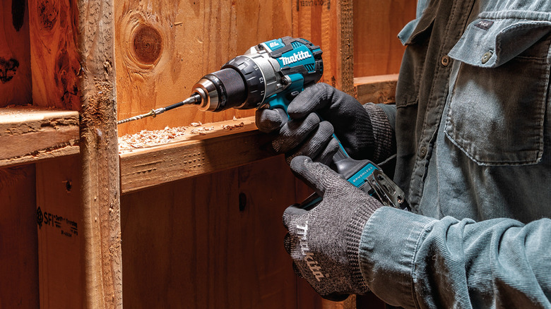 Person screwing in screw with drill