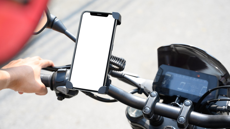A smart phone with white screen mounted on a motorcycle