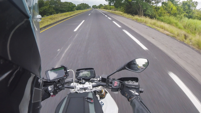 A biker wearing helmet using the mobile GPS navigation on his smart phone