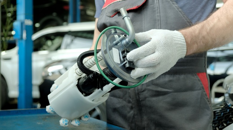 mechanic holding fuel pump