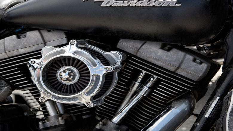 fragment of a motorcycle with the inscription Harley-Davidson on the gas tank and part of the engine with an air filter.