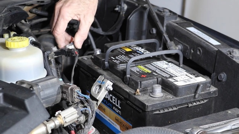 A person disconnecting their Cummins 12-volt battery