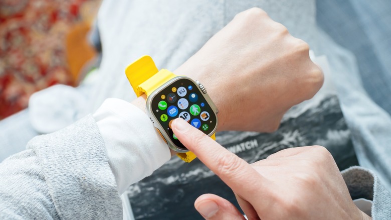 finger on Apple watch screen, pointng towards the Mail app icon