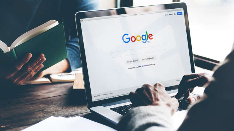 person browsing Google on laptop