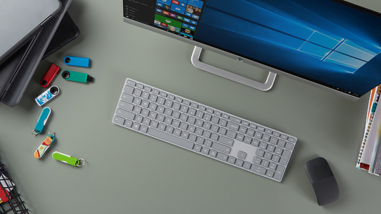 Desktop with Windows computer, keyboard, mouse, and some USB sticks