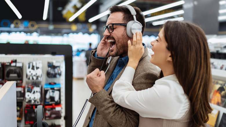 People trying on headphones in store