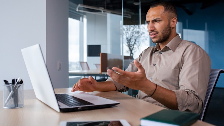 man looking frustrated at laptop