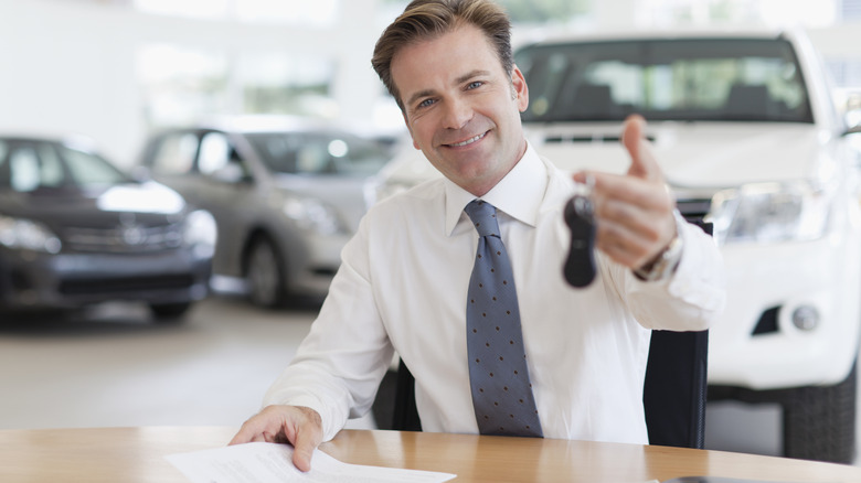 Car dealer salesperson holding keys