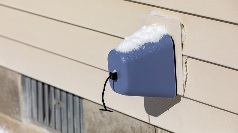 Snow melting on a covered outdoor faucet