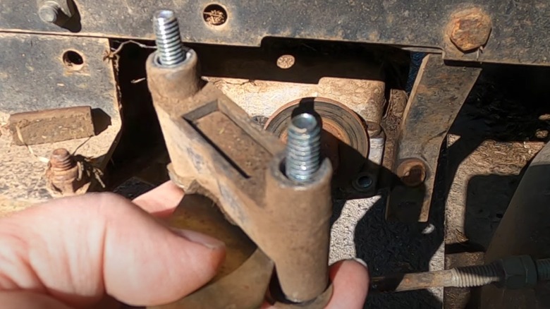 A person holding their mower's brake assembly.