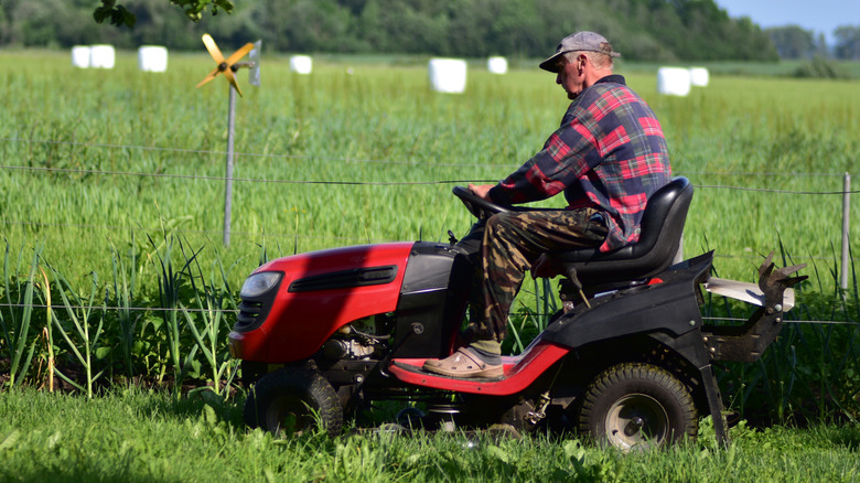 A person on a riding lawn mower.