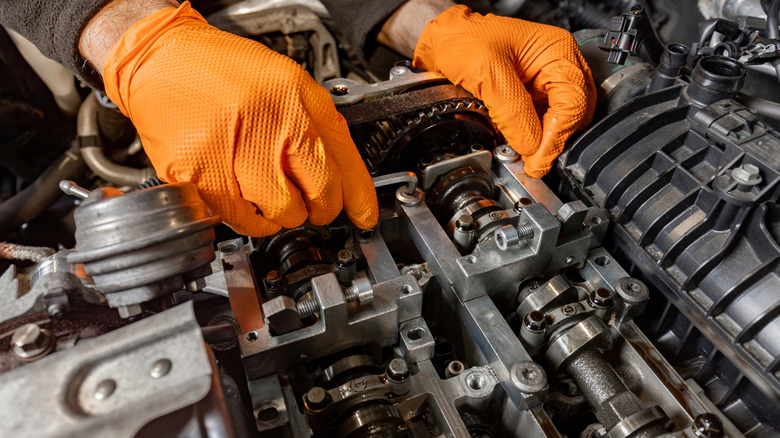 Technician servicing camshafts and timing in double overhead cam engine