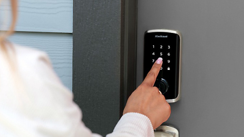 Woman entering access code in Kwikset smart lock