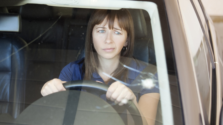 motorist looking at cracked windshield