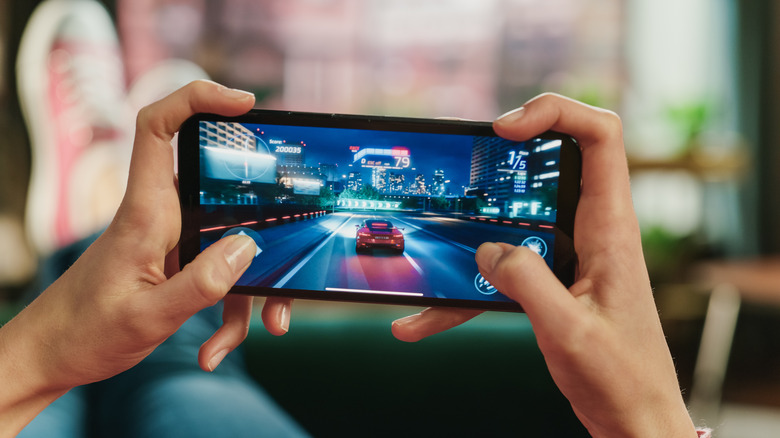 Person kicked back and relaxing while playing games on smartphone