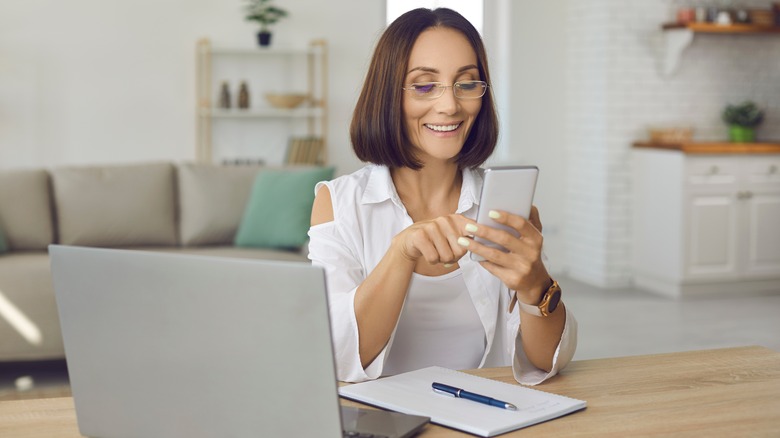 woman on phone and laptop