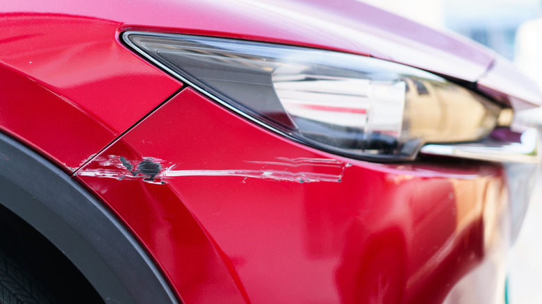 Red Mazda with damaged bumper