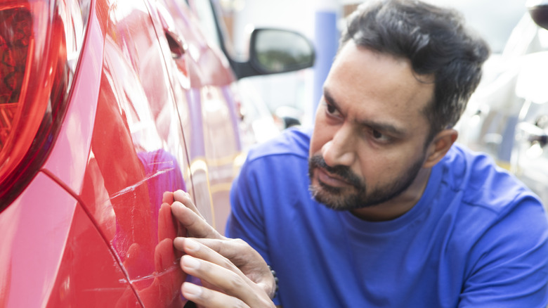Man examining car's bodywork