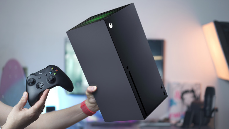 person holding xbox series x and controller