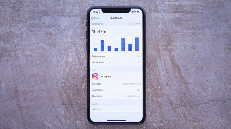 iPhone on gray surface showing screen time usage
