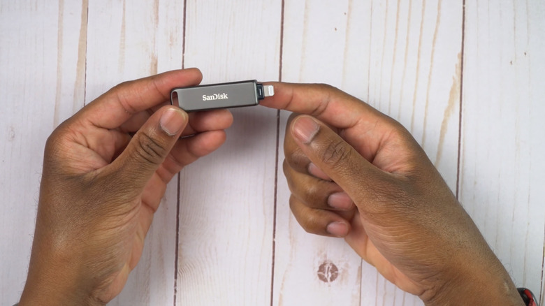 Hand holding SanDisk iPhone flash drive