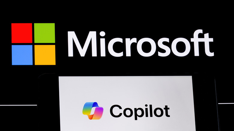 Copilot logo on phone in front of Microsoft logo