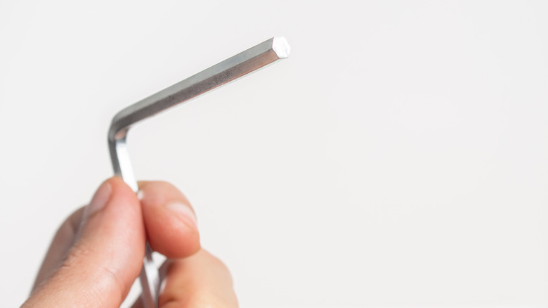 fingers holding allen wrench