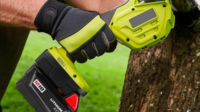 A person using a power tool battery adapter on a tool.