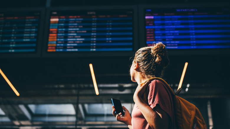 A lady looking at a screen with flight information.