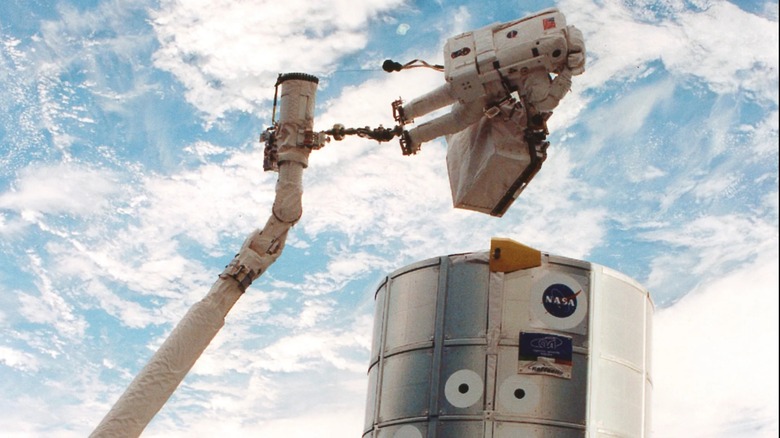 Astronaut attached to the robotic arm of the ISS