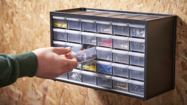 Hand pulls out drawer on Stanley 30-Drawer Multi-Purpose Storage Bin
