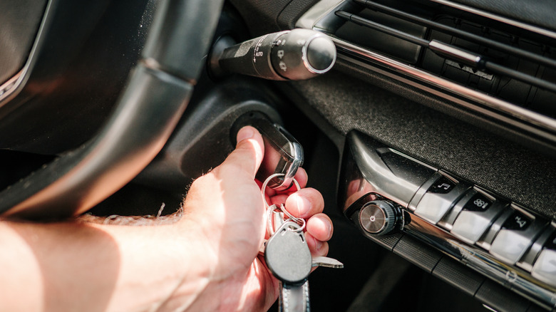 Hand turning key in the ignition