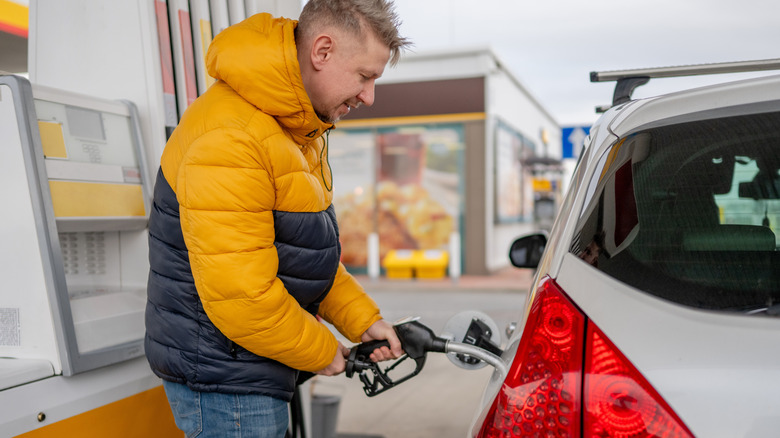 A man refueling his car at a gas station.
