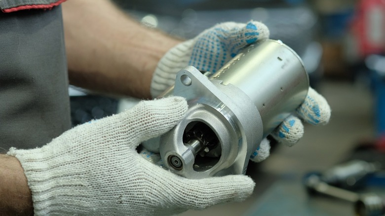 A person holding a new car starter